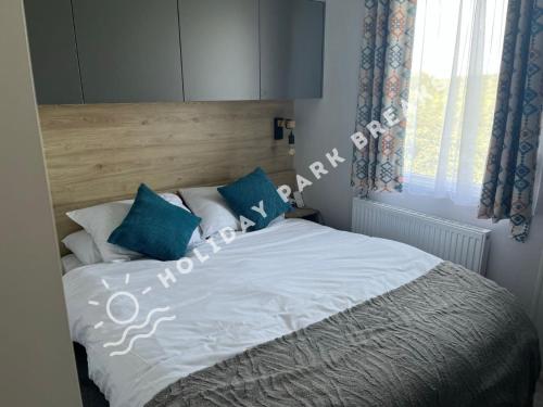 1 dormitorio con 1 cama con almohadas azules y blancas en Sunset - A Relaxing Gold 3 bed holiday home at Seal Bay Resort, en Chichester