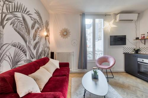 un salon avec un canapé rouge et une table dans l'établissement Studio cosy proche de l'Arc de Triomphe - 2P, à Paris