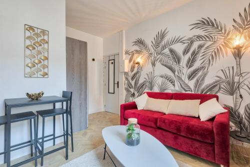 un salon avec un canapé rouge et une table dans l'établissement Studio cosy proche de l'Arc de Triomphe - 2P, à Paris