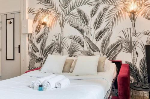 une chambre avec un lit avec un papier peint tropical dans l'établissement Studio cosy proche de l'Arc de Triomphe - 2P, à Paris