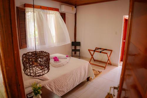a small room with a bed and a chair at Ecohotel Yachay Tayrona in El Zaino