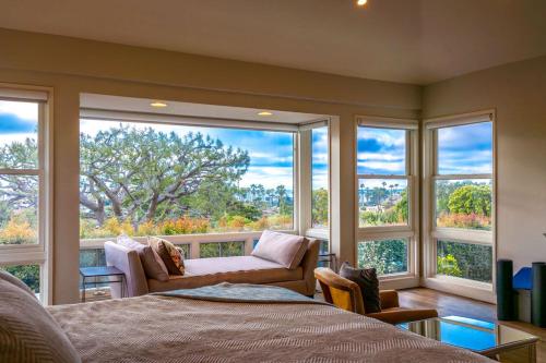 a room with a bed and a couch and windows at Walk to Beach Stunning Views La Jolla Shores in San Diego