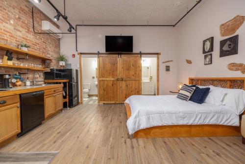 a bedroom with a bed and a kitchen with a television at Hartwell Suites in Hartwell