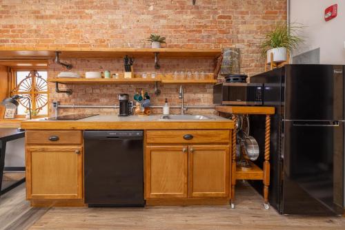 a kitchen with a sink and a black refrigerator at Hartwell Suites in Hartwell
