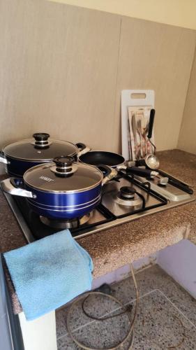 a stove top with two pans on top of it at Doña Elena in Punto Fijo