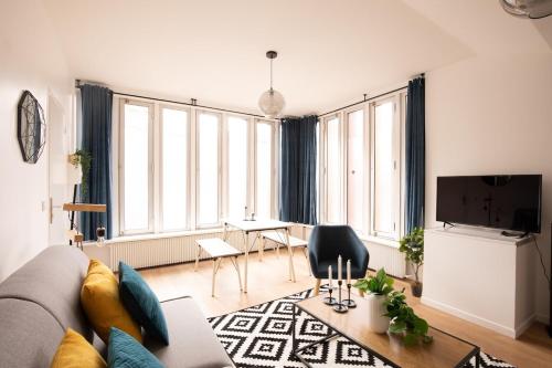 a living room with a couch and a table at Appartement lumineux proche Parc de la Villette in Paris