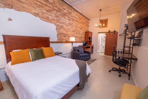 a bedroom with a bed and a brick wall at Hartwell Suites in Hartwell