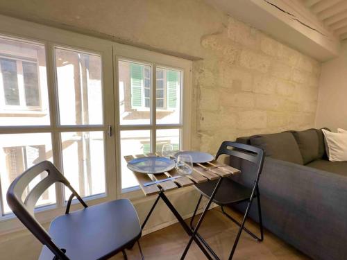 ein Wohnzimmer mit einem Tisch, Stühlen und einem Sofa in der Unterkunft Studio Hyper Centre in Avignon