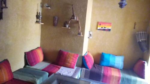 a room with a couch with colorful pillows at Dar El Ghali in Er Rachidia