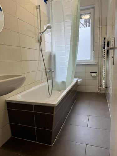 a bathroom with a bath tub and a sink at BERLIN PUR - Wohnung für bis zu 12 Personen in Berlin