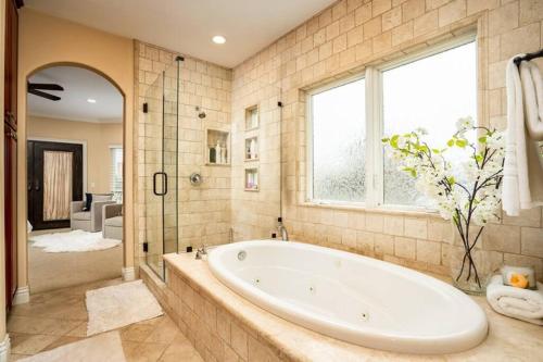 La grande salle de bains est pourvue d'une baignoire et d'une douche. dans l'établissement Luxury Beach House Rooftop Deck, à Huntington Beach