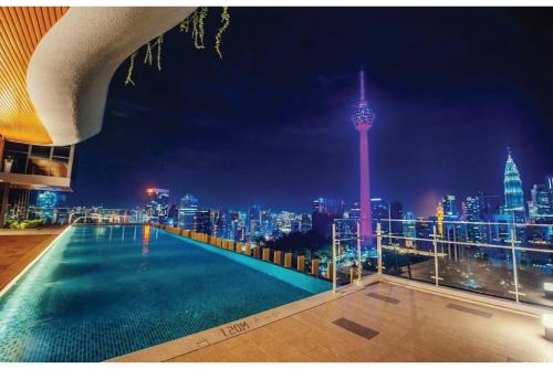 a view of a city skyline at night with a swimming pool at Infinity Pool Ceylonz Suites KLCC in Kuala Lumpur