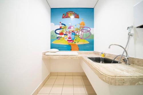 a bathroom with a sink and a wall with a mural at Beach Park Resort - Wellness in Aquiraz