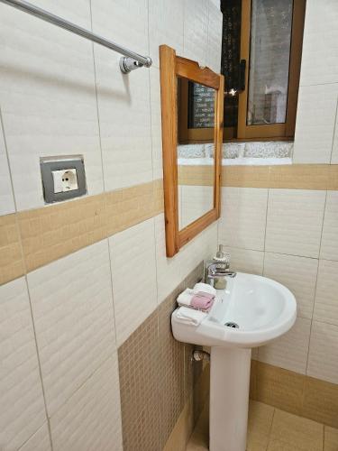 uma casa de banho com um lavatório e um espelho em Rigas stone tower east Mani 3 em Mína