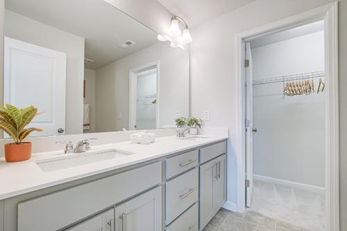 ein weißes Badezimmer mit einem Waschbecken und einem Spiegel in der Unterkunft Clayton Townhome about 13 Mi to Downtown Raleigh! in Garner
