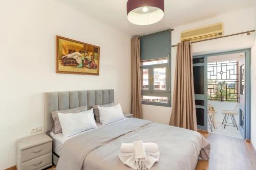 een slaapkamer met een groot wit bed en een raam bij Moroccan typical flat, Hivernage in Marrakesh