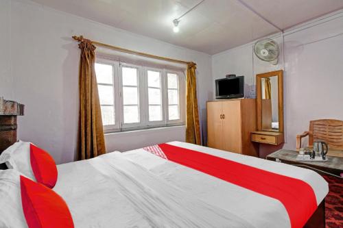 OYO Flagship Rest A While في سريناغار: غرفة نوم بسرير احمر وبيض ونافذة