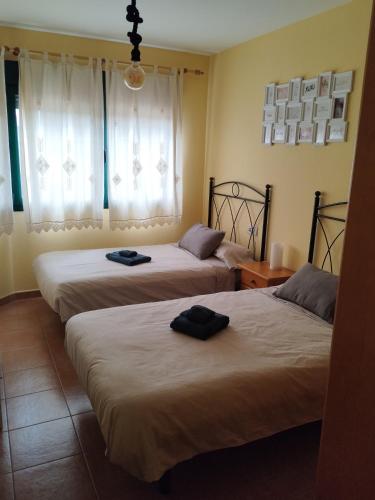 two beds in a hotel room with towels on them at karluchi a Mariña 2 Barreiros in Barreiros