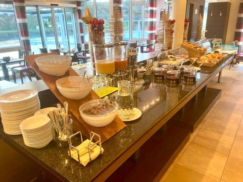 uma linha de buffet com pratos e tigelas de comida em Garni Hotel Henn em Simmerath