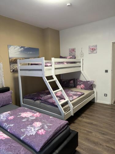 two bunk beds in a room with purple beds at BERLIN PUR - Wohnung für bis zu 12 Personen in Berlin