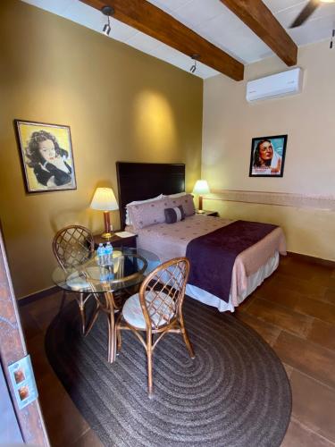 a bedroom with a bed and a table and chairs at Hotel Casa María Félix in Álamos
