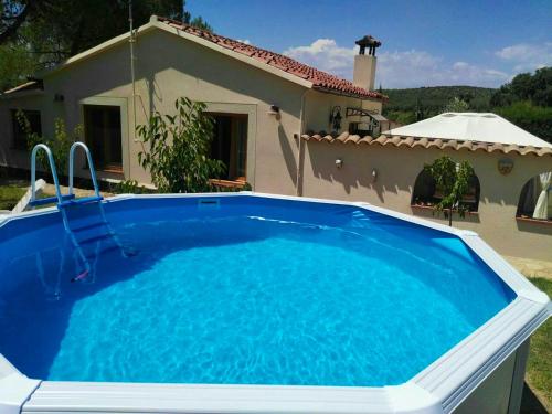 a large blue swimming pool in front of a house at Cosy Chalet in L'Arboçar with Private Pool, 65 sqm in Barcelona