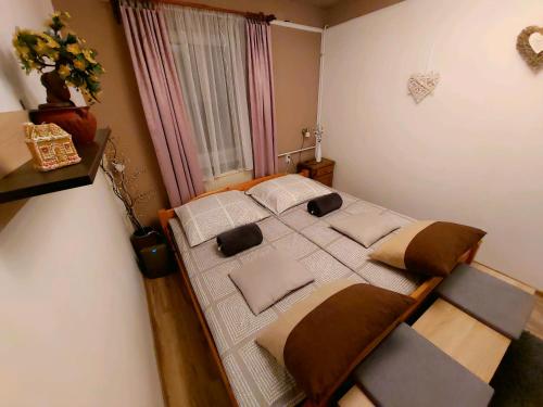 Un dormitorio con una cama con almohadas. en Kata Vendégház, en Sátoraljaújhely