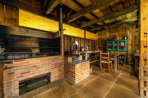 - une cheminée en briques dans une pièce avec un bar dans l'établissement Pousada Morro Grande, à Bom Jardim da Serra