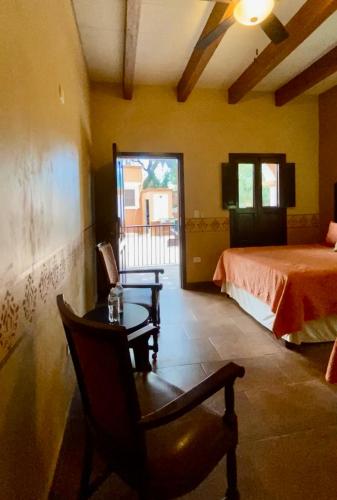 a bedroom with a bed and a chair and a table at Hotel Casa María Félix in Álamos