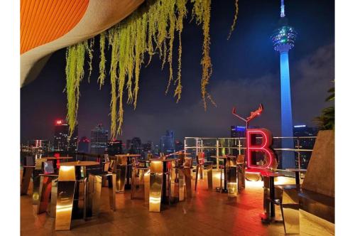 a restaurant with a view of auckland city at night at Infinity Pool Ceylonz Suites KLCC in Kuala Lumpur