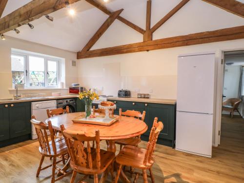 Newfield Farm Cottages في بلاندفورد فوروم: مطبخ وغرفة طعام مع طاولة وكراسي خشبية
