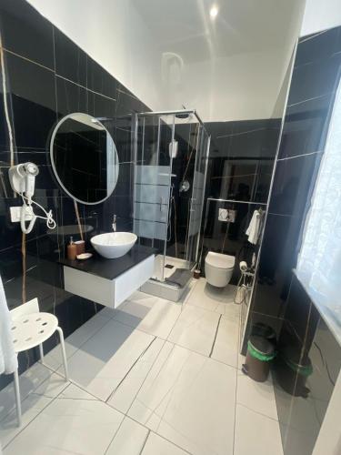 La salle de bains est pourvue d'un lavabo et d'un miroir. dans l'établissement Laura Rooms, à La Spezia