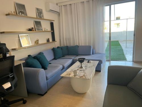 a living room with a blue couch and a table at Maria Louiza apartment NEAR CENTER in Athens