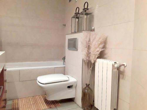 a white bathroom with a toilet and a bath tub at One bedroom property with wifi at Zaragoza in Zaragoza