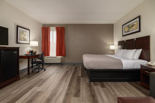 a hotel room with a bed and a desk at Quality Inn & Suites Lexington South in Lexington