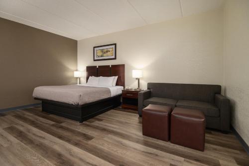 a hotel room with a bed and a couch at Quality Inn & Suites Lexington South in Lexington