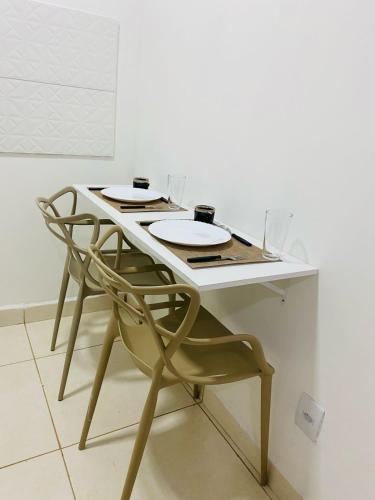 - une table blanche avec deux chaises et des verres dans l'établissement DuPai 10 Sorocaba, à Sorocaba