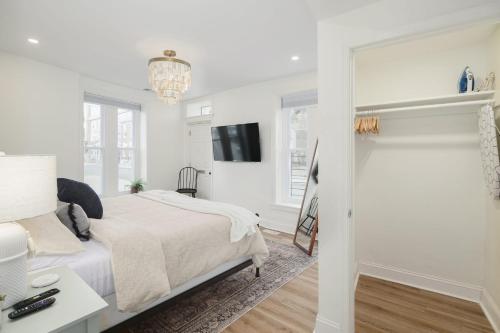 a white bedroom with a bed and a tv at Silverwood Serenity: Large 2b 2b with Parking in Philadelphia