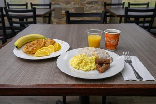 two plates of breakfast food on a wooden table at Quality Inn & Suites Lexington South in Lexington