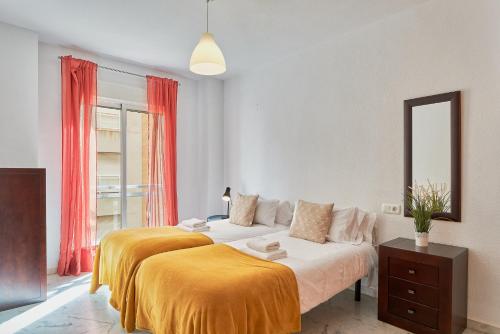 1 Schlafzimmer mit 2 Betten und einem Spiegel in der Unterkunft Mercy Beach in Málaga