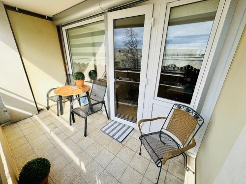 een terras met een tafel en stoelen op een balkon bij Sunset View Apartment with Logia in Ettlingen