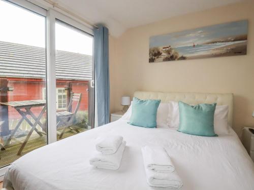 - une chambre avec un grand lit et une grande fenêtre dans l'établissement The Hideaway, à St Austell