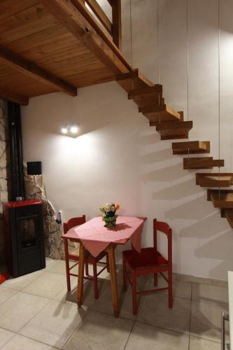 a dining room with a table and a staircase at Il Cottage di Stella incantevole appartamento in SantʼOreste