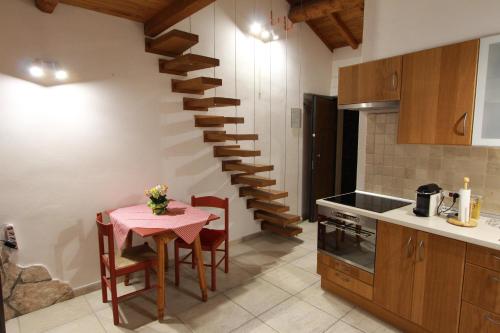 a kitchen with a table and a spiral staircase at Il Cottage di Stella incantevole appartamento in SantʼOreste