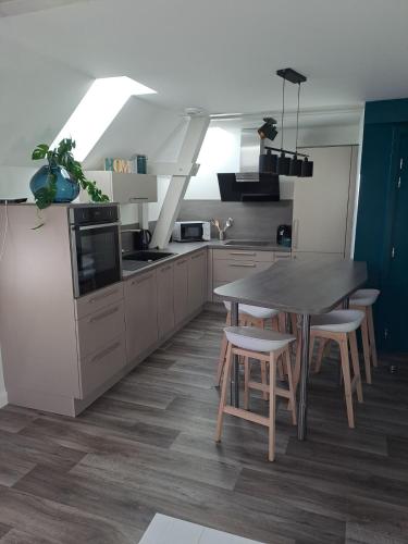 une cuisine avec une table et quelques chaises dans l'établissement Appartement 3 pièces tout confort, Aux Portes de Colmar, à Andolsheim
