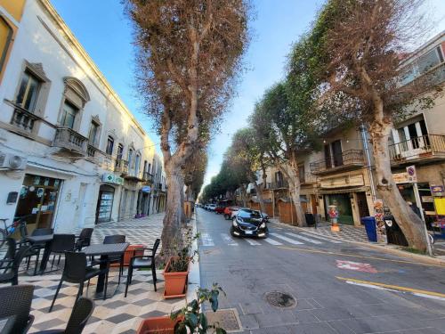 a car driving down a city street with trees at La brezza marina in SantʼAntìoco