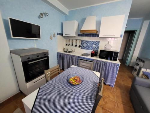 a kitchen with a table with a bowl of fruit on it at La brezza marina in SantʼAntìoco