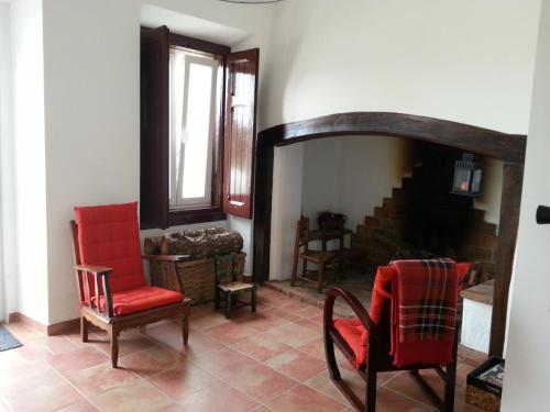 a living room with two chairs and a fireplace at Casas da Moagem in São Domingos