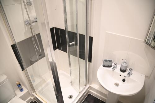baño blanco con ducha y lavamanos en Windsor to Heathrow spacious 2 Bedroom 2 Bath Apartment with Parking - Langley village Elizabeth Line to London, Reading, Oxford en Slough