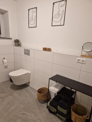 a white bathroom with a toilet and a table at FeWo Mösle in Lautrach